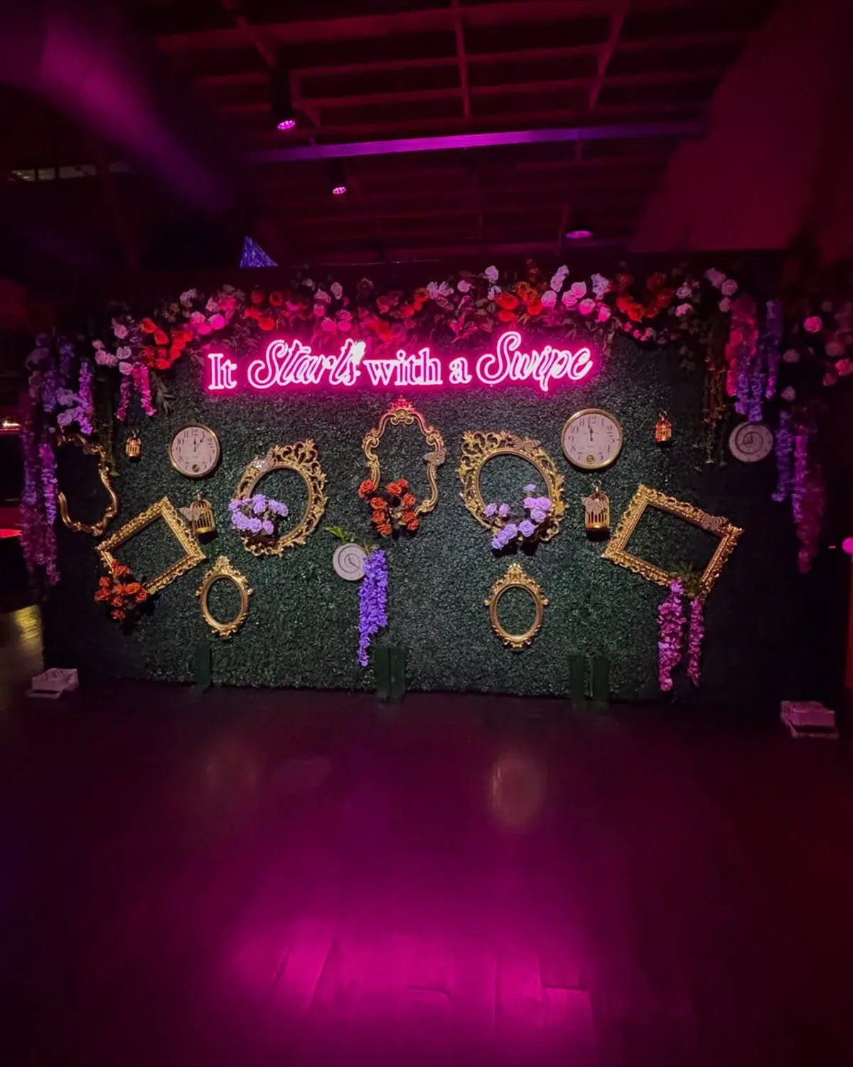 Neon sign photo wall with floral and gold frame decor for a brand activation