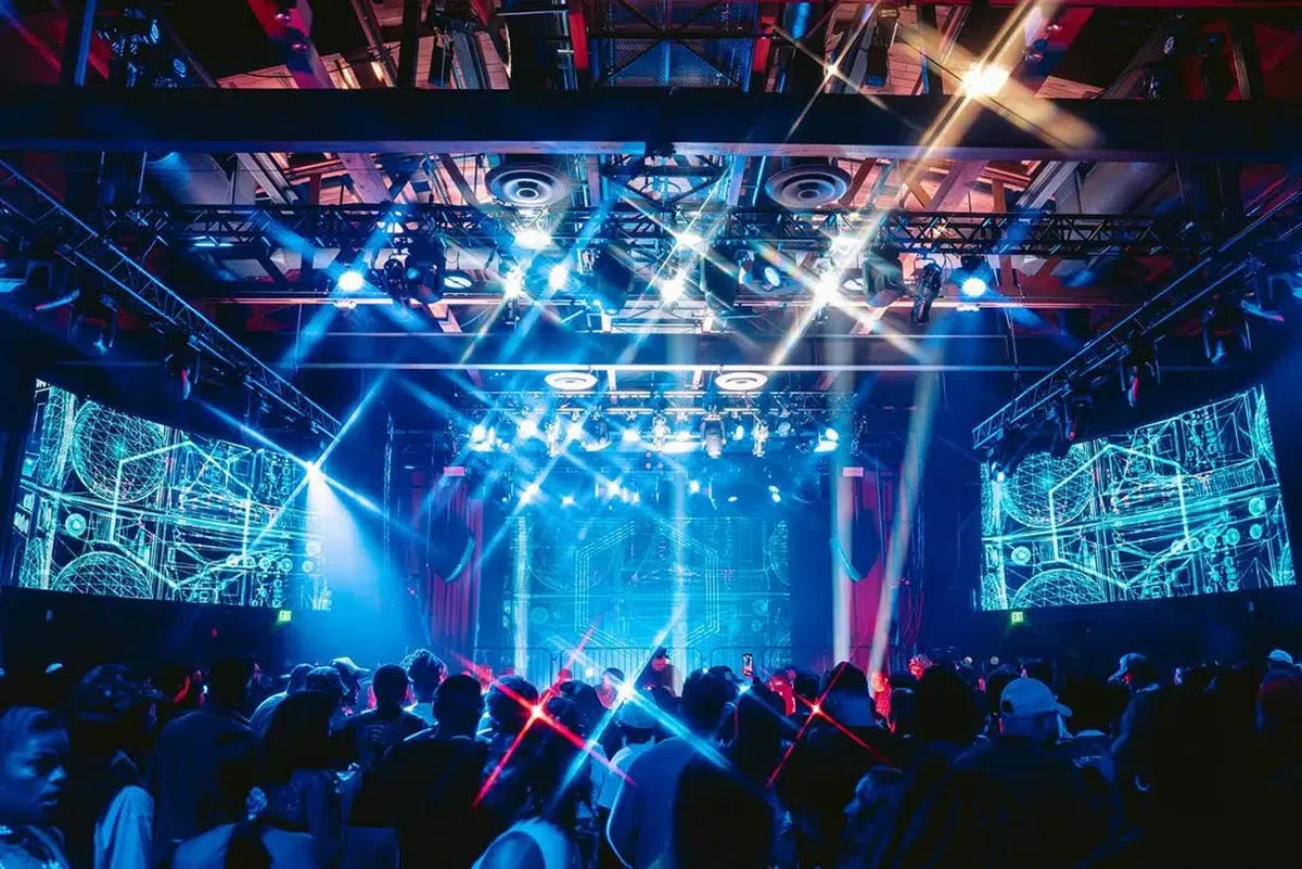 Concert crowd under blue stage lighting and LED screens at Vermont Hollywood