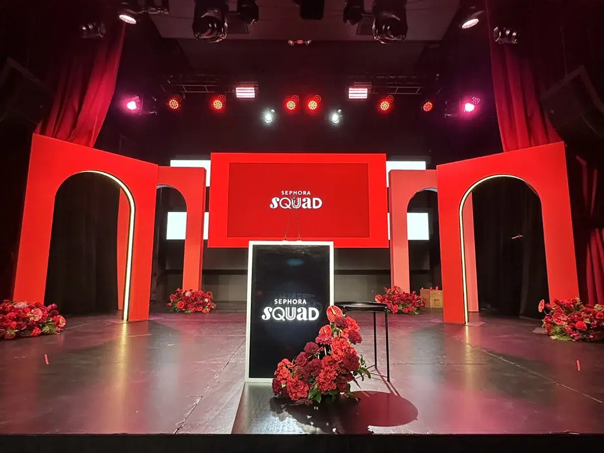 Red velvet curtain entrance with branded projection beneath The Vermont Hollywood sign at corporate brand activation event